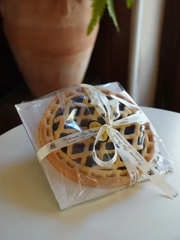 Crostata scura artigianale con marmellata e pasta frolla decorata a griglia, confezionata con nastro Pasticceria San Romolo Sanremo