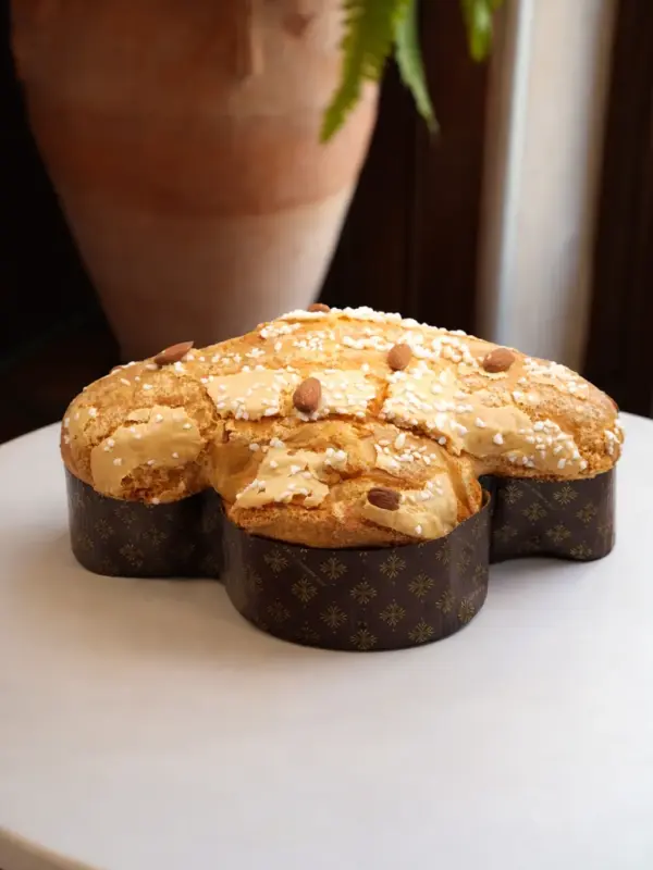 Colomba artigianale pasquale con glassa di mandorle e granella di zucchero su tavolo elegante - Pasticceria Caffè San Romolo Sanremo